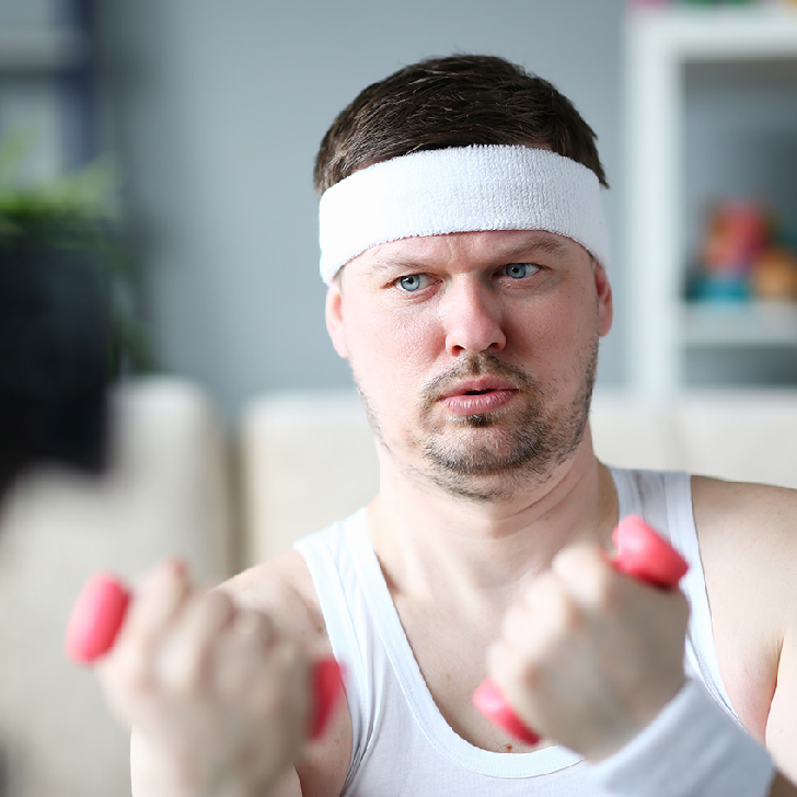 Harry Weiner wearing a headband and lifting comically small pink weights